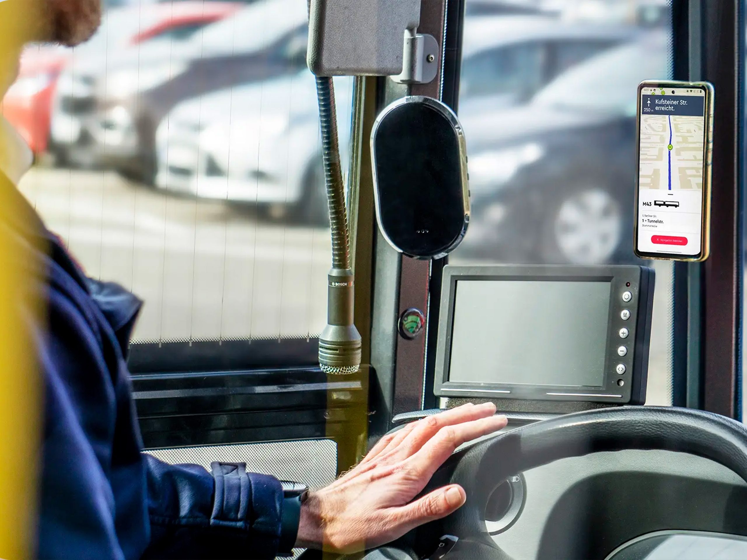 Frau im Anzug steht mit dem Smartphone vor einem schwatzen Fahrzeug